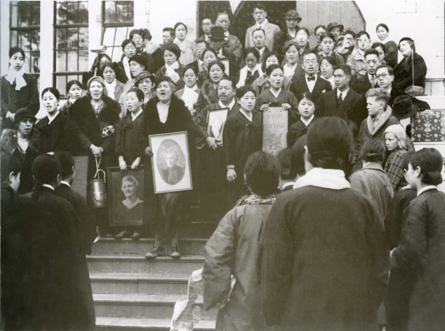 7-1. 이화학당 설립자 스크랜튼 여사(M.F.Scranton)의 사진을 품은 아펜젤러 교장이 신촌캠퍼스 본관 앞에 도착한 후 찬송가를 부르고 있다. 1935.jpg